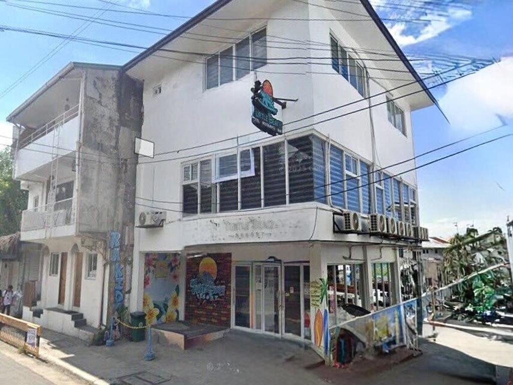 a white building with a painting on the side of it at Turtle Beach Resort in San Juan