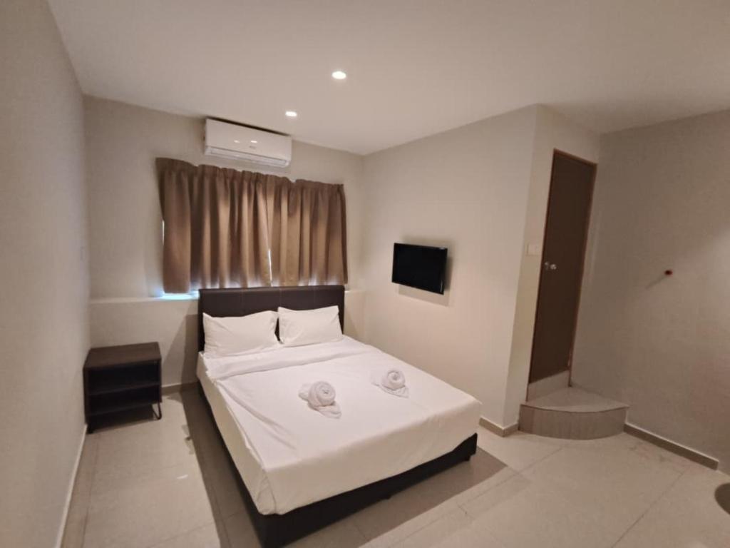 a bedroom with a bed with two towels on it at Swing & Pillows - Bukit Tinggi, Klang in Klang