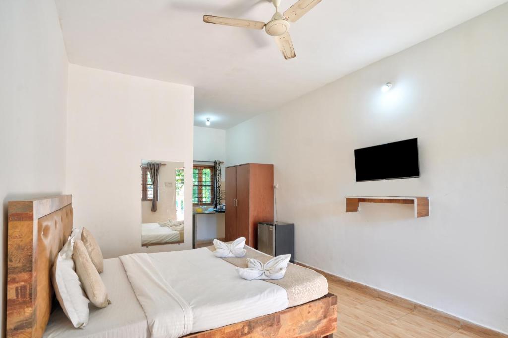 a bedroom with a bed and a flat screen tv at Hotel Calangute bay in Calangute