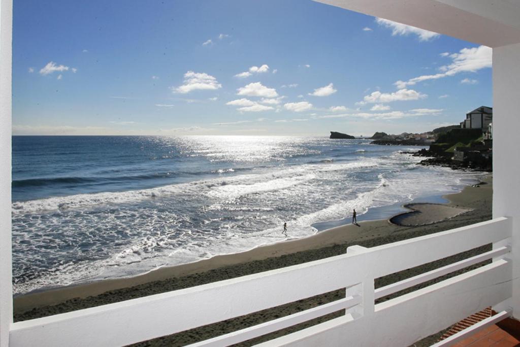 a view of the ocean from the balcony of a house at Aparthotel Barracuda in Ponta Delgada