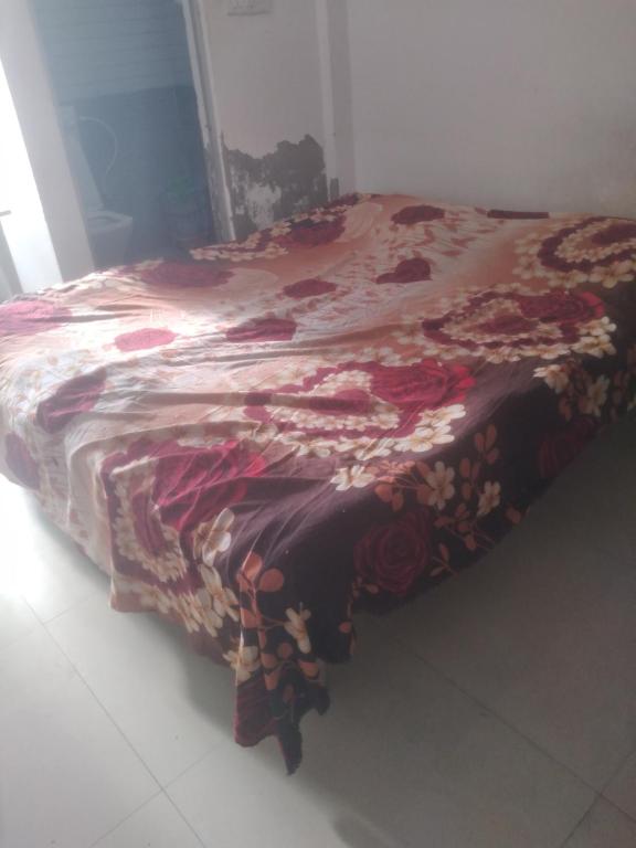 a bed with a flowered blanket on top of it at relief villa in Lucknow