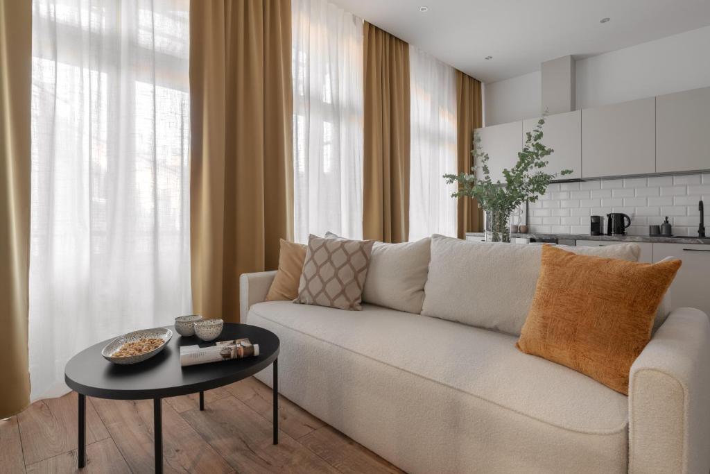 a living room with a white couch and a table at HARBOR APARTMENTS - Mickiewicza in Katowice