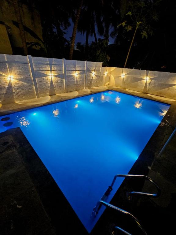 a swimming pool lit up at night with lights at Dreamy serenity beach side in Pondicherry