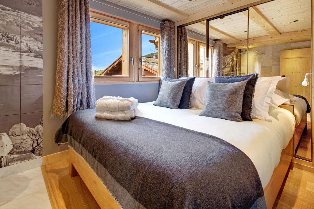 a bedroom with a large bed with a window at Chalet-Hôtel Inarpa in La Clusaz