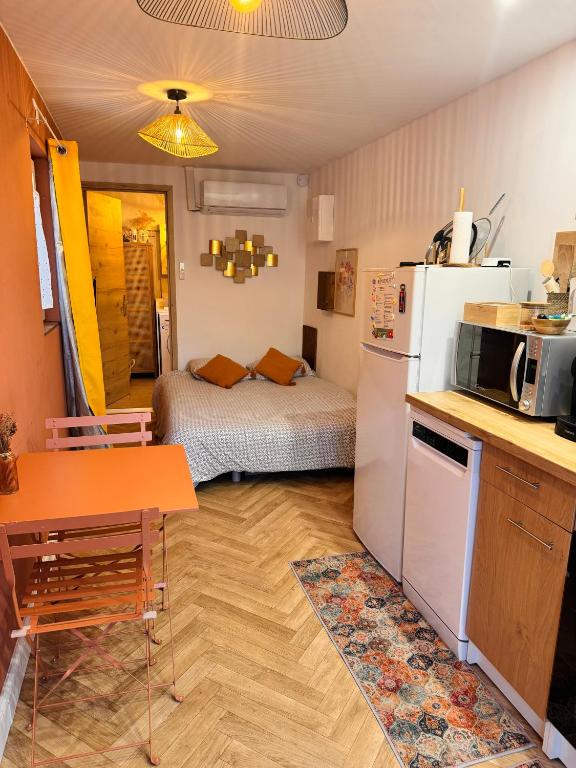 a small kitchen with a refrigerator and a table at Gite du paradis in Le Luc