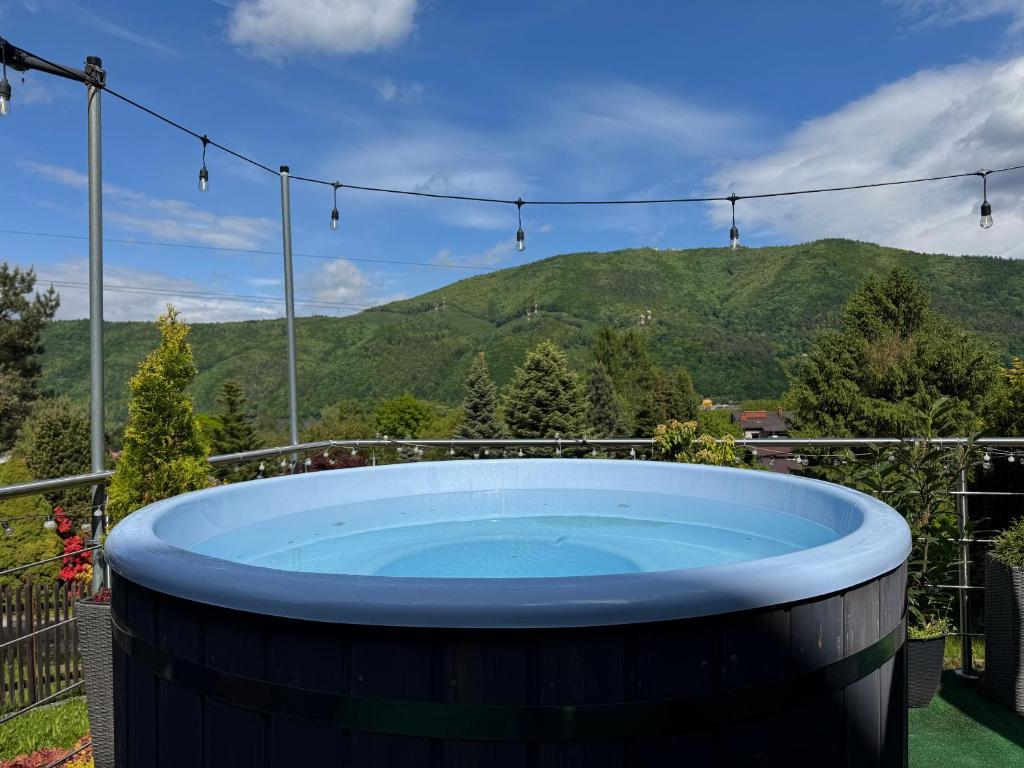 a hot tub on the patio with mountains in the background at Willa Kotelnica in Międzybrodzie Bialskie