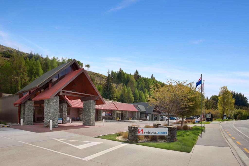 a building with a sign in front of a street at Swiss-Belresort Coronet Peak in Queenstown