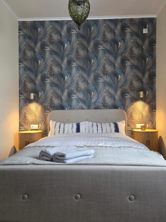 a bedroom with a large bed with a large headboard at Arashenda nest in Arashenda