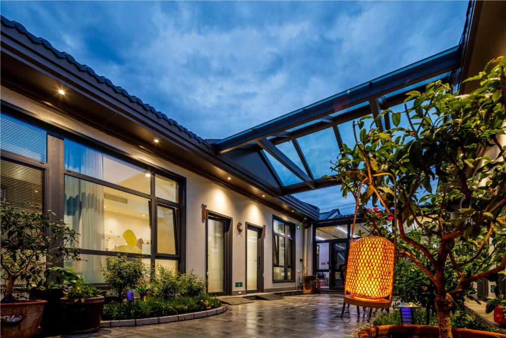 an enclosed patio with an orange chair and plants at LeD Courtyard Homest ay乐东小院民宿 in Beijing