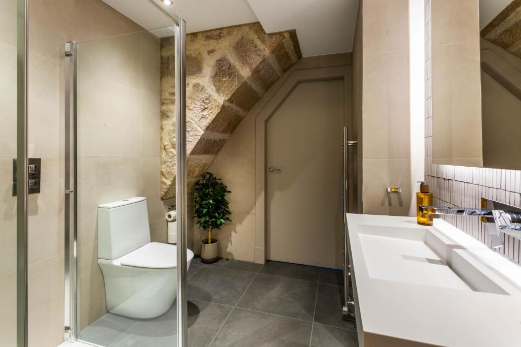 a bathroom with a toilet and a sink at Arran Shores Luxury Shorefront Apartment 14 in Lamlash