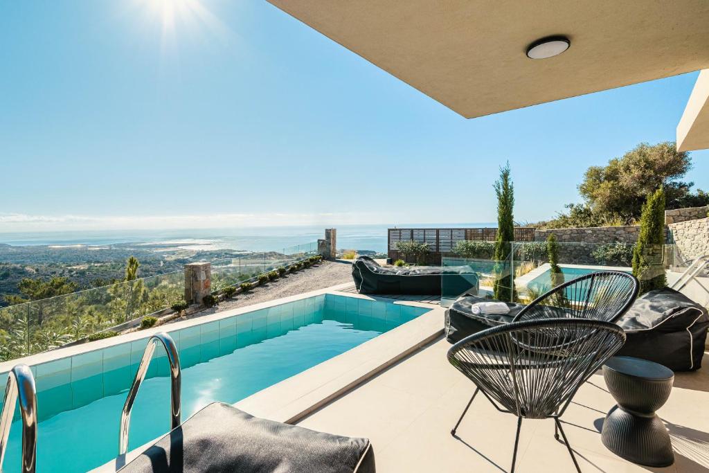 a villa with a swimming pool with a view at Thea Villas in Makry Gialos
