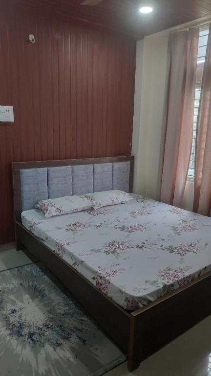 a bedroom with a large bed with a floral bedspread at The Siiying in Pāsighāt
