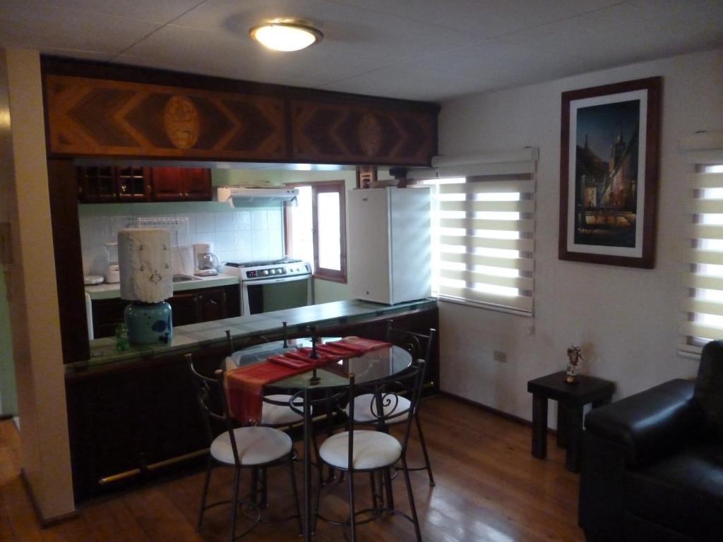 a kitchen with a counter and a table and chairs at APARTAMENTO CENTRO HISTÓRICO DE QUITO in Quito