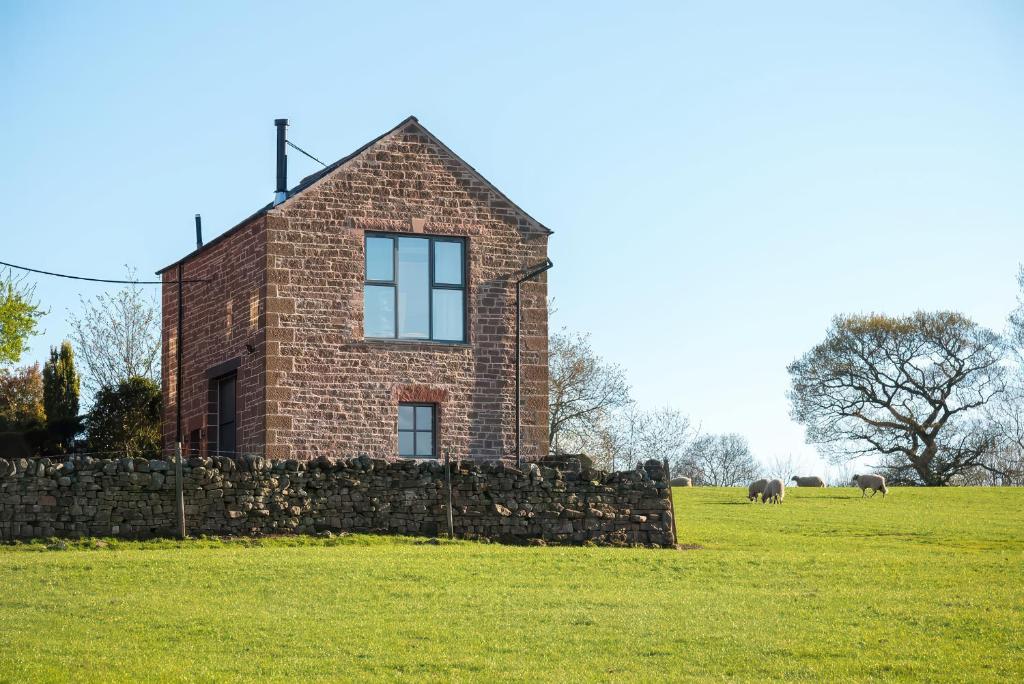 a brick house in a field with two elephants in the background at Shepherds View in Dufton