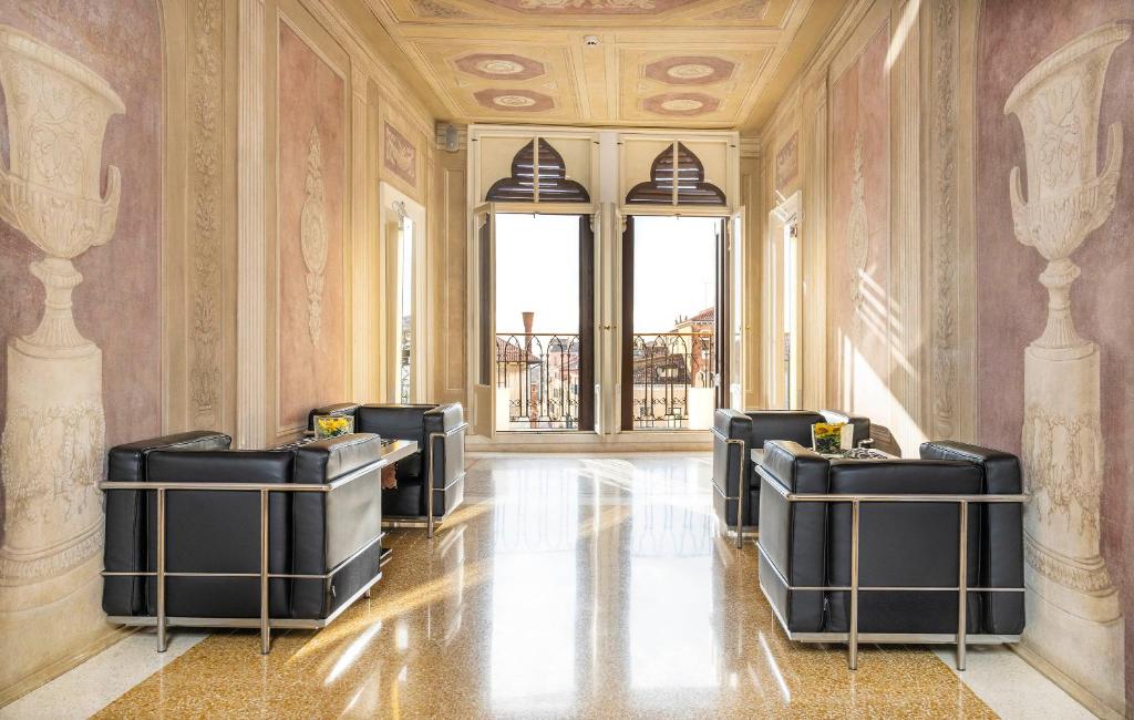 a salon with black chairs in a room at Maison Spada in Venice
