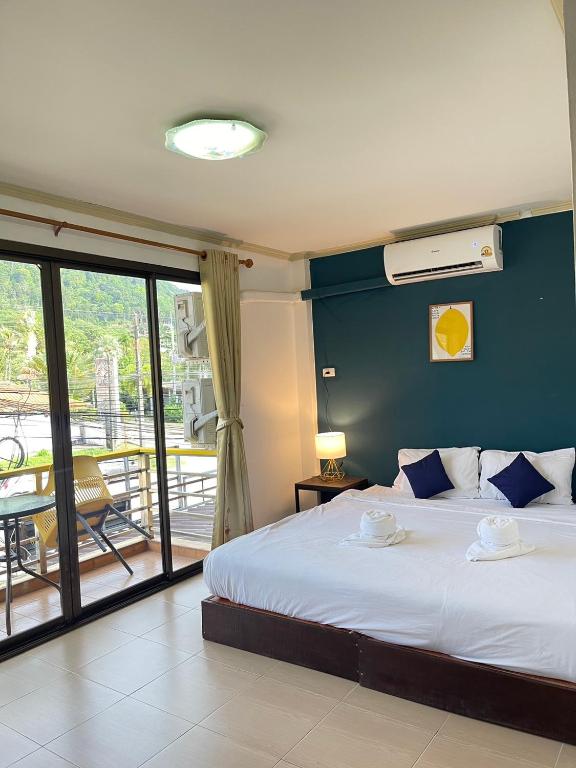 a bedroom with a bed with a blue wall at Lemon Inn in Ko Lanta
