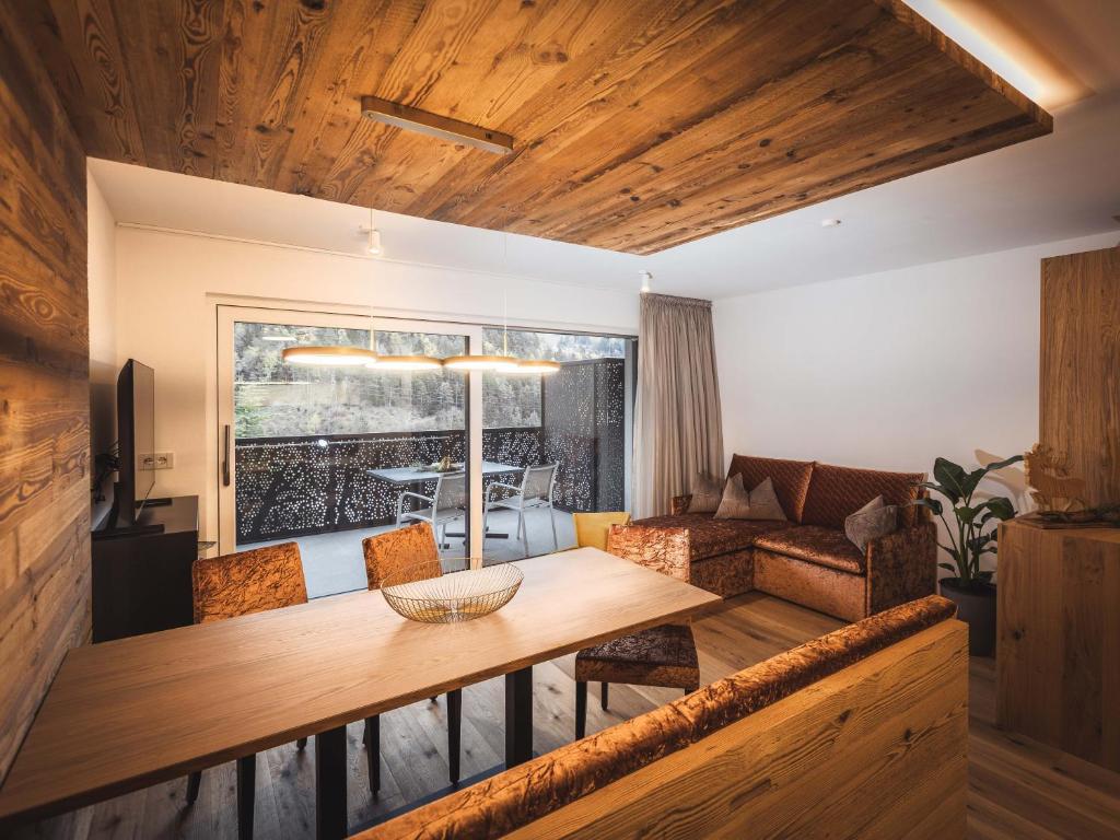 a living room with a table and a couch at Paradeis Apartments in Mühlbach