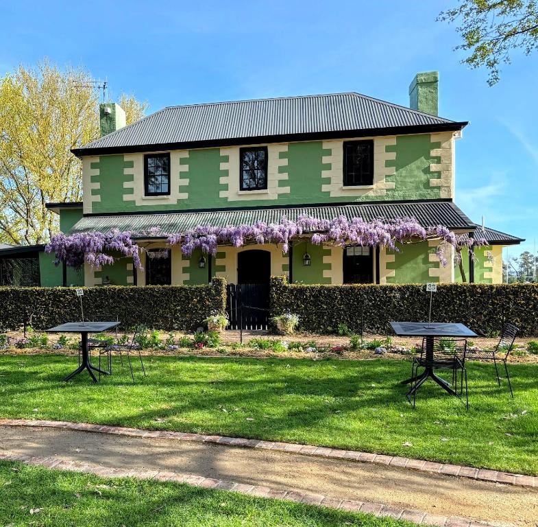 a green house with two picnic tables in front of it at Bathurst River House B & B in Bathurst