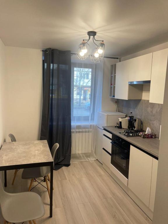 a small kitchen with a table and a dining room at Loft Like View in Izmail