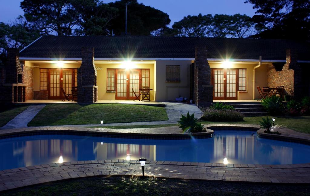 a house with a swimming pool at night at African Aquila Guest Lodge in Port Elizabeth