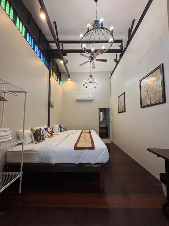 a bedroom with a bed and a chandelier at Reuan Vilawan Waterfront in Ban Nong Chaeng