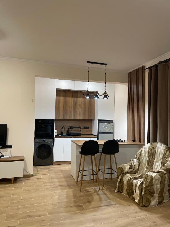 a kitchen with a table and two bar stools at Home Kodjori in Kojori