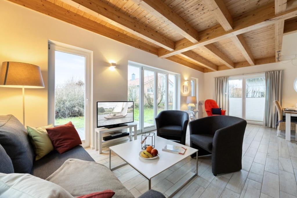 a living room with a couch and chairs and a tv at Rapsblütenhaus in Bohnert