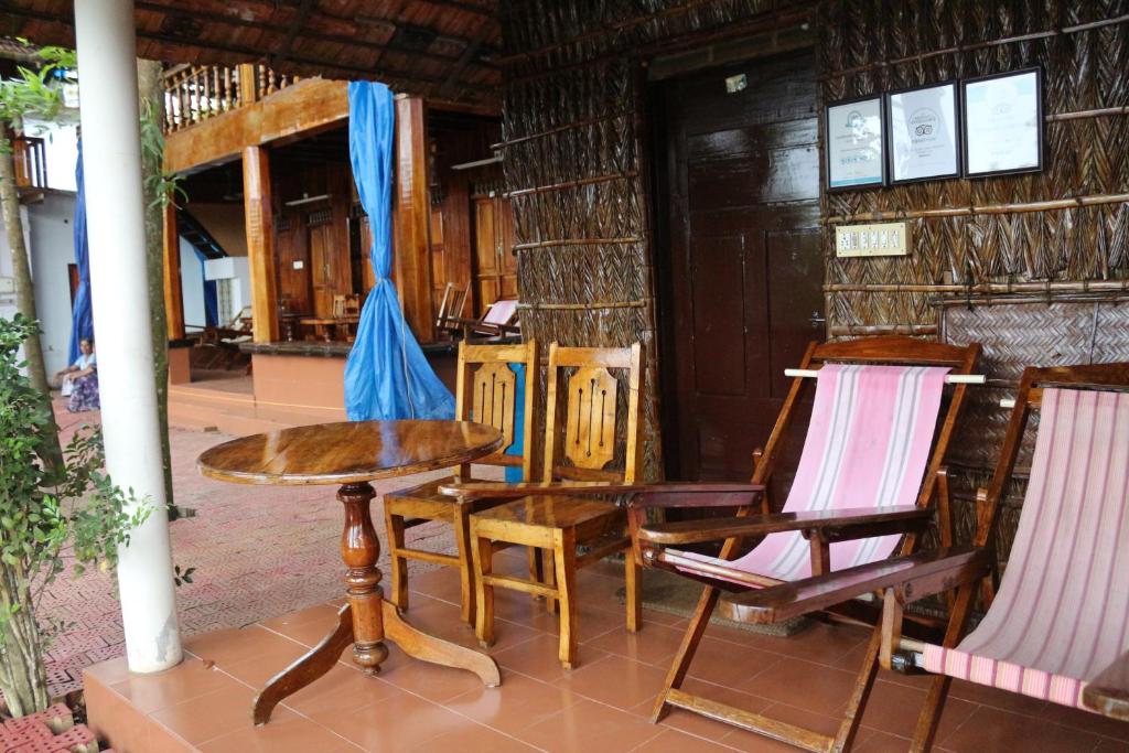 a table and chairs in front of a building at Malayalam Lake Resort in Alleppey