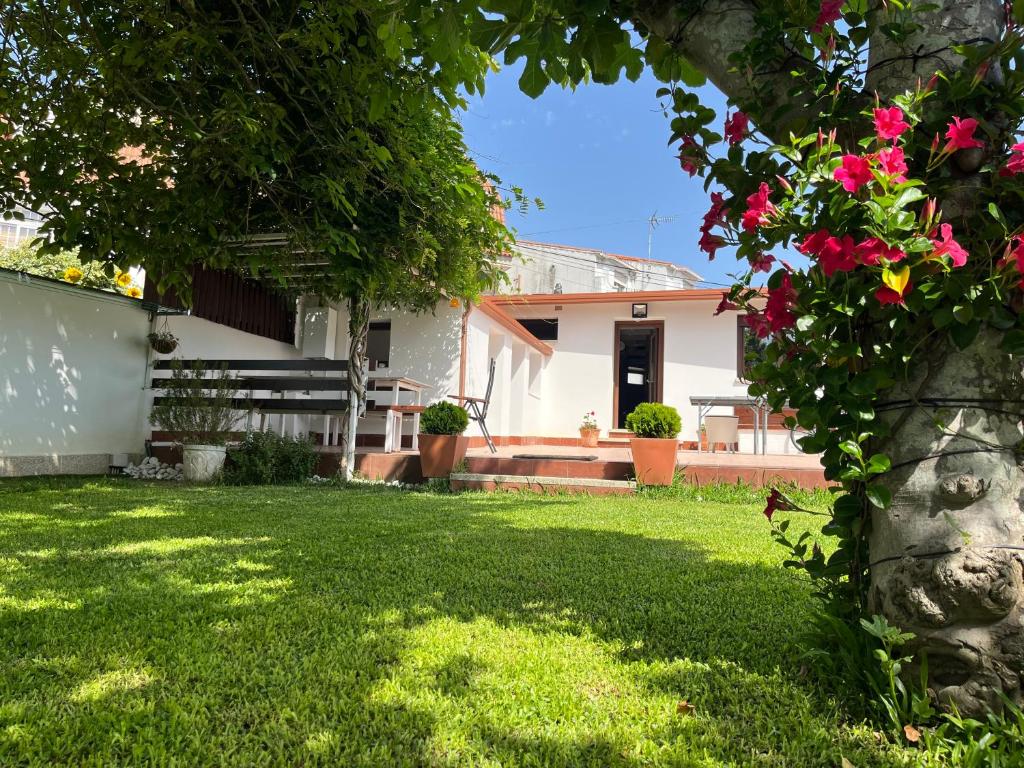 a house with a yard with pink flowers at Casa Divarro in O Grove