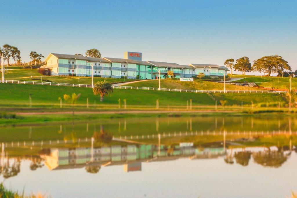 a building next to a body of water at Hotel Ecovilly in Santo Antônio