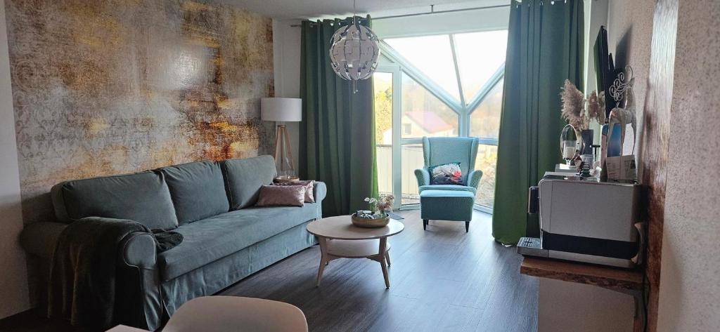 a living room with a blue couch and a table at Ferienwohnung mit Weinbergblick in Radebeul