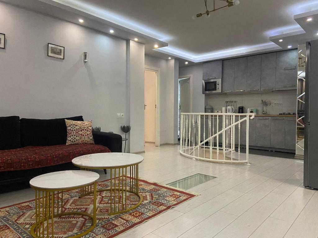 a living room with a couch and two tables at Behind the Parliament Building in Tbilisi City