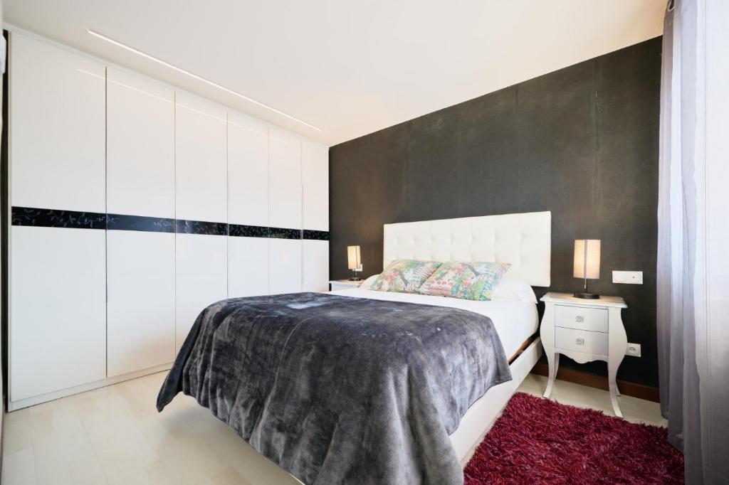 a bedroom with a bed and a black wall at Los Respigos Laredo in Laredo