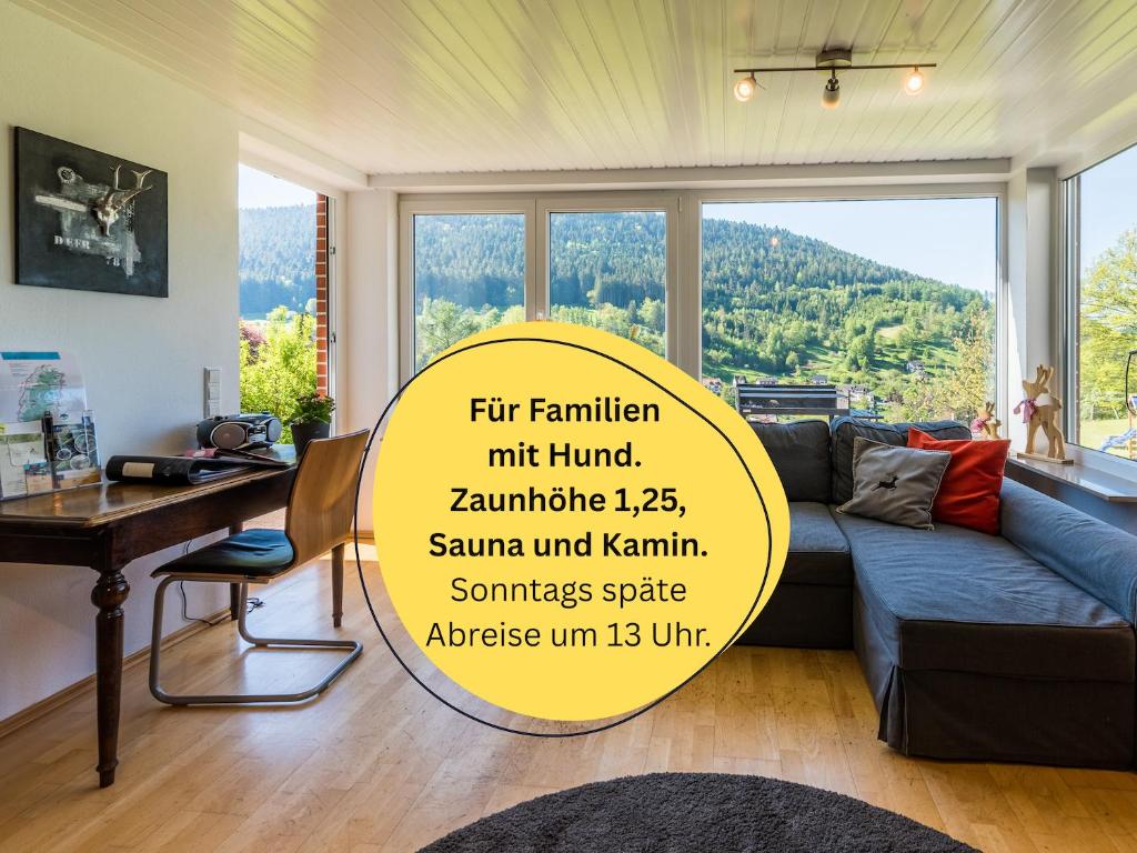 a living room with a blue couch and a table at Burghalde: Sauna | Kamin | Garten | eingezäunt in Alpirsbach