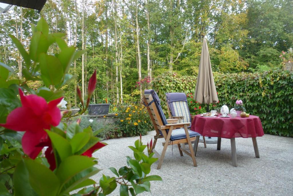 eine Terrasse mit einem Tisch, Stühlen und einem Sonnenschirm in der Unterkunft Apartment Heidelinde in Gmunden