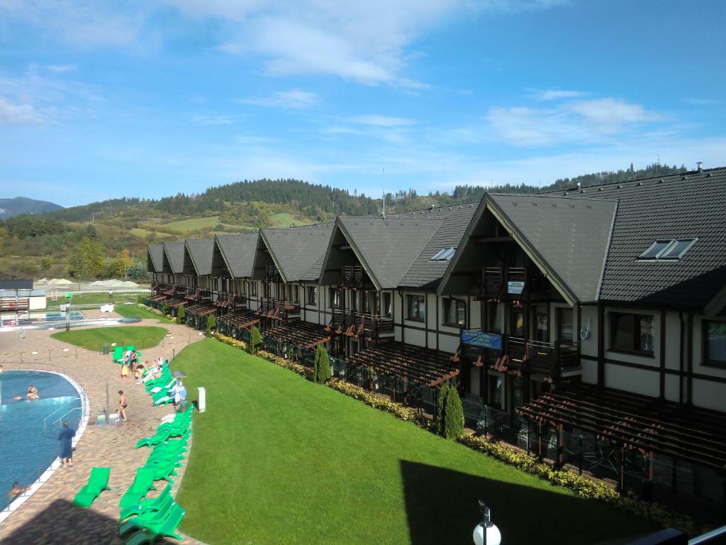 a resort with a pool and chairs and people on the beach at Apartament 325 in Bešeňová