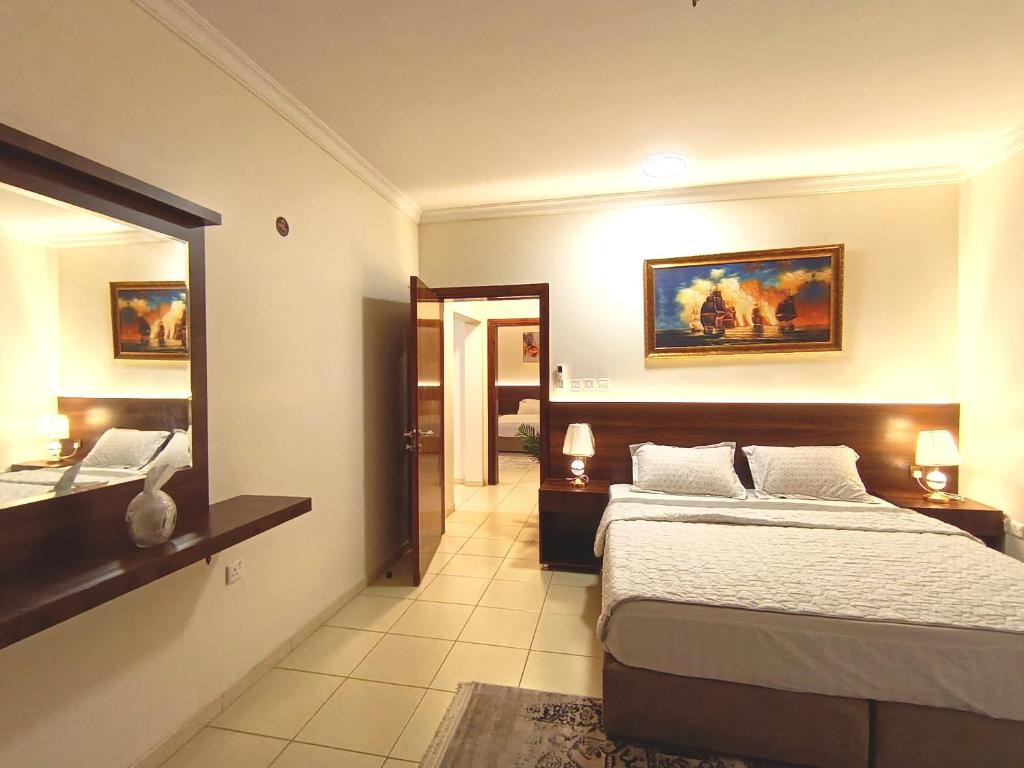 a hotel room with a bed and a mirror at شقة العقيق الأولى in Medina