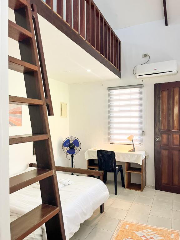 a bedroom with a bunk bed and a desk at Surfside Bungalows in General Luna