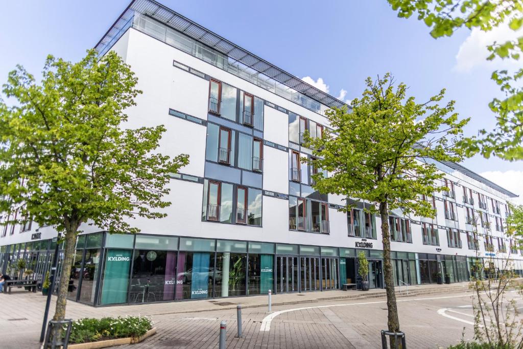 a white building with trees in front of it at Hotel Kolding in Kolding