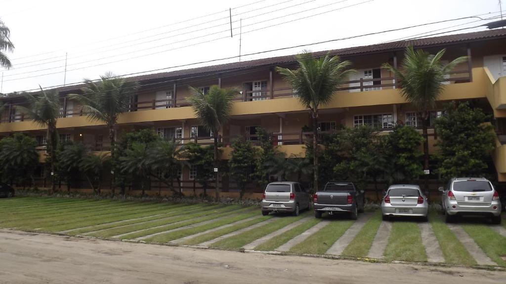 a parking lot in front of a building with parked cars at Amarilis Flat Apartament in Riviera de São Lourenço