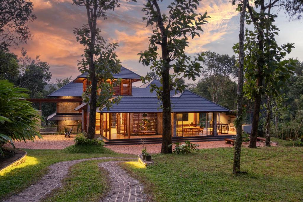 a house in the middle of a forest at CardMem Hills View Pool Villa & Resort, Thekkady in Thekkady