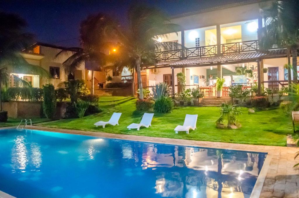 a villa with a swimming pool at night at Residenza Canoa in Canoa Quebrada