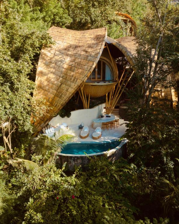 a resort with a swimming pool and a house at Cocoon Reserve in Kuta Lombok
