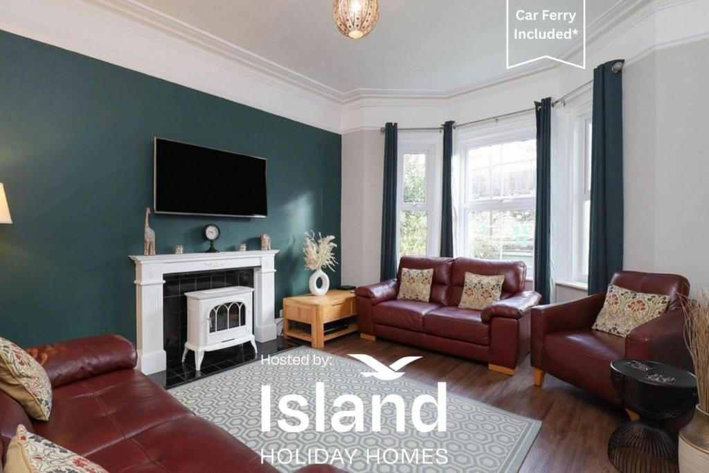 a living room with a couch and a fireplace at Kenmare Cottage in Shanklin