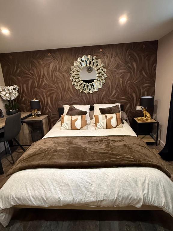 a bedroom with a large bed with a mirror on the wall at Serenity's Home in Naintré