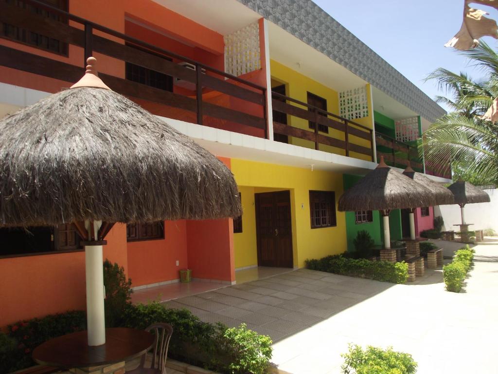 a hotel with a building with a patio and umbrella at Privê Maragogi Residence in Maragogi