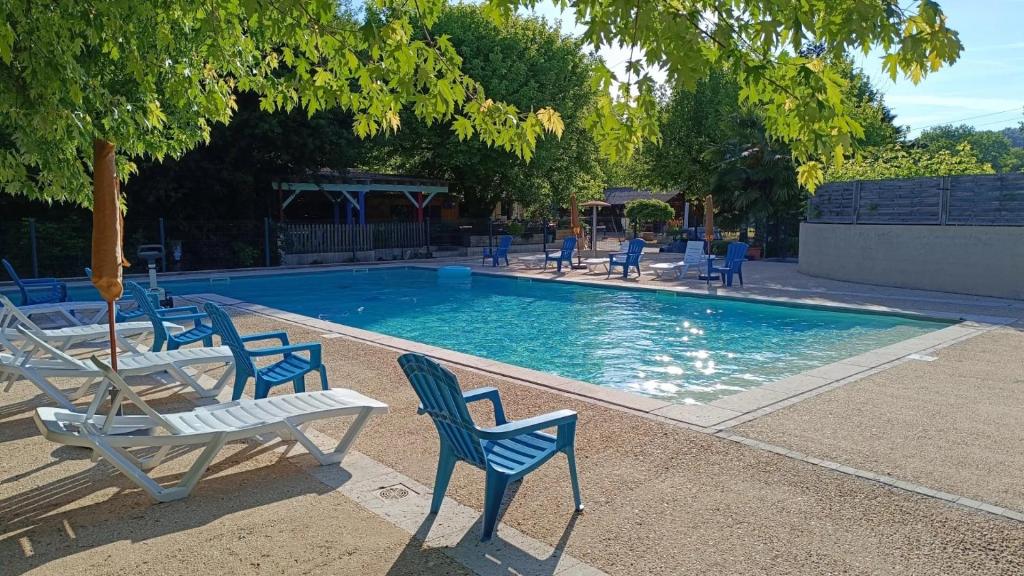 a swimming pool with blue chairs and a table at ZEcamping 3 étoiles - piscine chauffée haute saison in Antonne-et-Trigonant