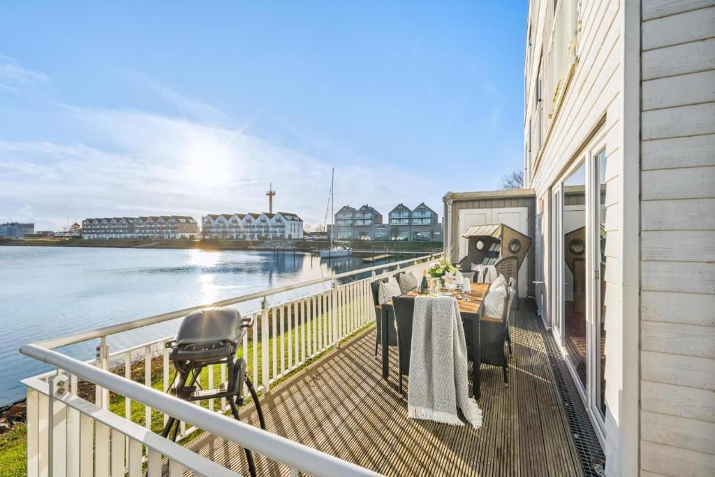 a balcony with a table and chairs next to the water at Annas Heimat am Meer in Kappeln