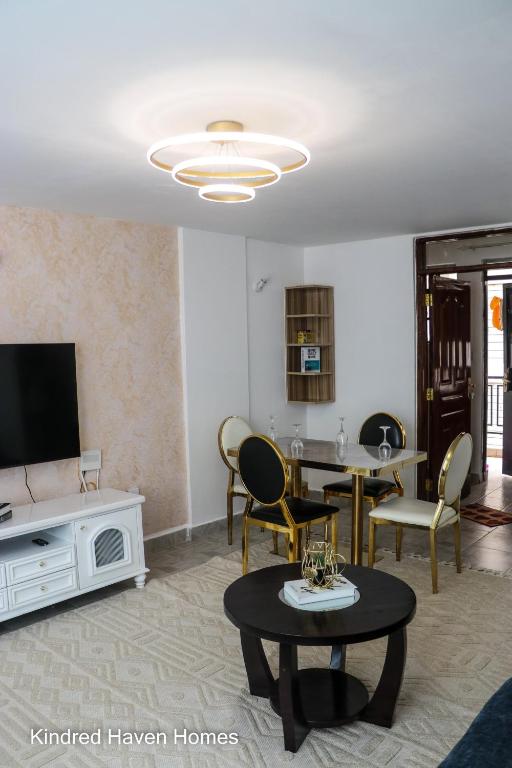 a living room with a tv and a table and chairs at Machakos Town 3 Bedroom Ensuite in Machakos