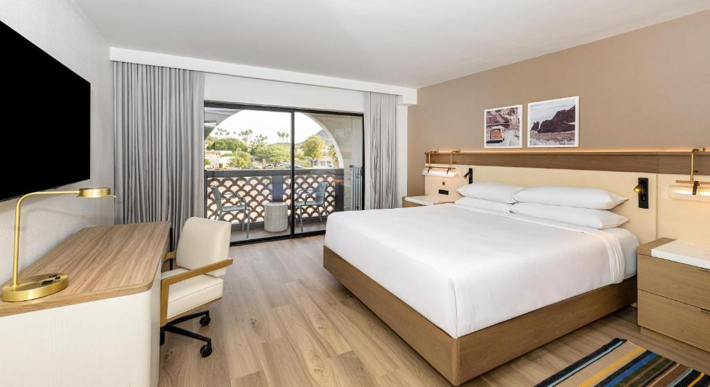a hotel room with a bed and a desk and a computer at Hilton Phoenix Resort at the Peak in Phoenix